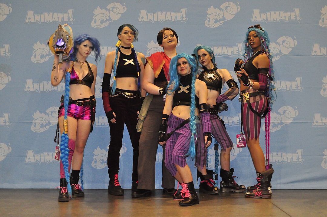 Cosplayeurs costumés en personnages d'Arcane lors d'une convention.